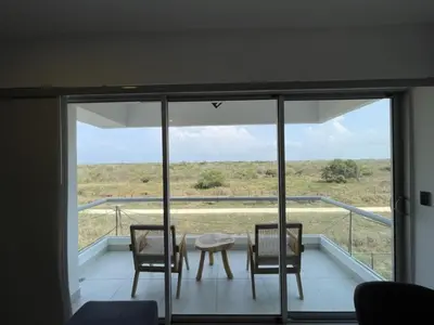 a room with three chairs and a table on a balcony at Castelo - Serena Del Mar in Puerto Tierrabaja
