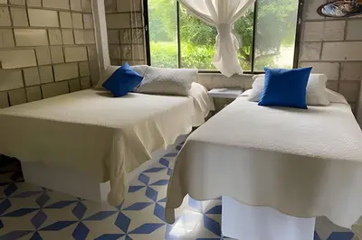 two beds in a room with blue pillows on them at Tu Casa de playa frente al mar, Tolú te espera in Tolú