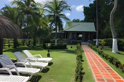 a row of white lounge chairs in a yard at Tu Casa de playa frente al mar, Tolú te espera in Tolú