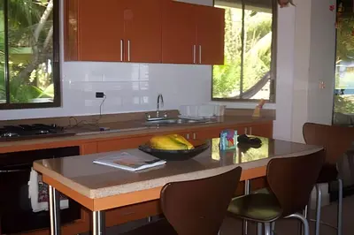 a kitchen with a table with a bowl of fruit on it at Tu Casa de playa frente al mar, Tolú te espera in Tolú