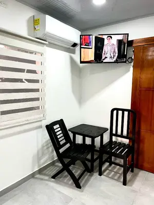 a room with a table and two chairs and a tv at Sol de Coveñas Caracol in Guayabal