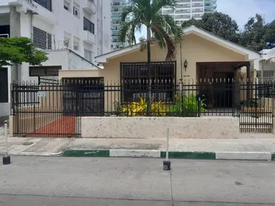 a building with a black fence and a palm tree at Casa Estela in Cartagena de Indias