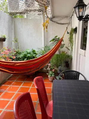 a hammock on a patio with a table and chairs at Casa Vilmar Getsemani in Cartagena de Indias