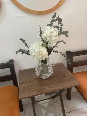 a vase with white flowers sitting on a table at Casa Vilmar Getsemani in Cartagena de Indias