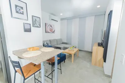 a living room with a table and chairs and a couch at Modern Apartment in Santa Marta in Santa Marta