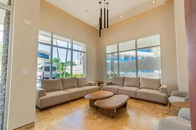 a living room with a couch and a table and windows at Modern Apartment in Santa Marta in Santa Marta