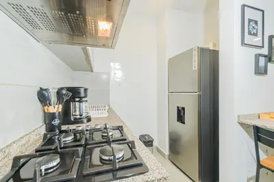 a kitchen with a stove and a stainless steel refrigerator at Modern Apartment in Santa Marta in Santa Marta