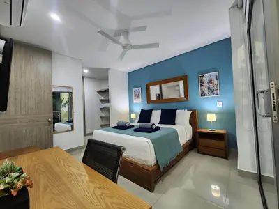 a bedroom with a bed with a blue wall at Bocagrande bay view gym jacuzzi pool in Cartagena de Indias