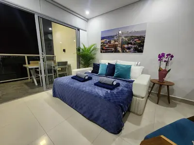 a bedroom with a king sized bed and a couch at Bocagrande bay view gym jacuzzi pool in Cartagena de Indias