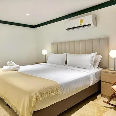 a bedroom with a large white bed with two lamps at by Calamari Homes - El Porvenir 207 walled city in Cartagena de Indias