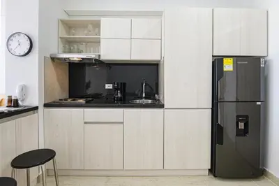 a kitchen with white cabinets and a black refrigerator at Apartasuit Cartagena luxury 1240 in Cartagena de Indias