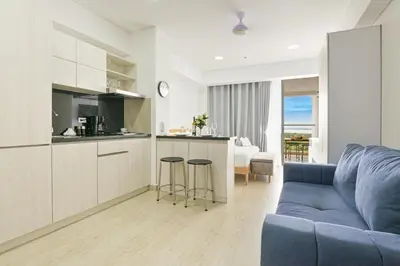 a living room with a blue couch and a kitchen at Apartasuit Cartagena luxury 1240 in Cartagena de Indias