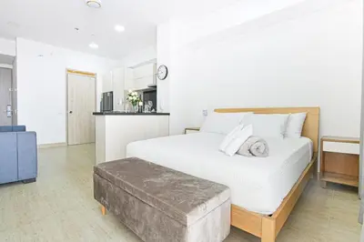a bedroom with a large white bed and a ottoman at Apartasuit Cartagena luxury 1240 in Cartagena de Indias