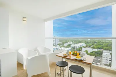 a dining room with a table and chairs and a large window at Apartasuit Cartagena luxury 1240 in Cartagena de Indias