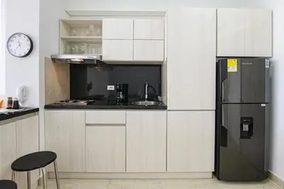 a kitchen with white cabinets and a black refrigerator at Luxurious Apartasuit CartagenaBeach1139 in Cartagena de Indias