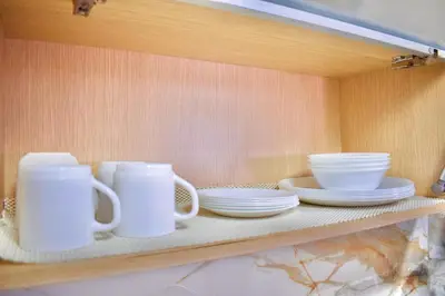 a shelf with white cups and plates on it at Exclusivo apartamento de lujo frente al mar en Los Morros, con acceso directo y privado a la mejor playa de Cartagena in Cartagena de Indias