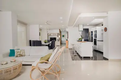 a white living room with a white couch and a table at Beachfront Condo in Cartagena in Cartagena de Indias