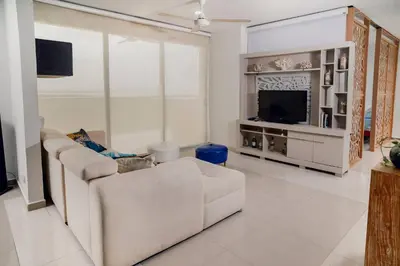 a living room with a white couch and a television at Beachfront Condo in Cartagena in Cartagena de Indias