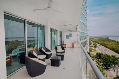 a balcony of a building with chairs and windows at Beachfront Condo in Cartagena in Cartagena de Indias