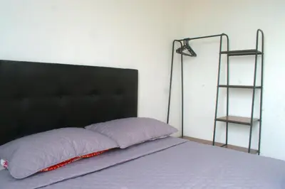 a bed with a black head board and a shelf at Hermoso Apartamento Cerca a Playa in Cartagena de Indias