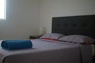 a bedroom with a bed with two pillows and a headboard at Hermoso Apartamento Cerca a Playa in Cartagena de Indias