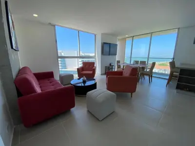 a living room with red couches and a dining room at Premium Hub 1304 APARTAMENTO CARTAGENA Vista al Mar in Cartagena de Indias