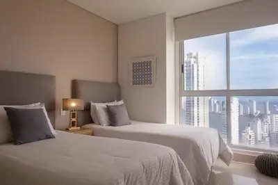 a bedroom with two beds and a large window at Murano Elite by MOME in Cartagena de Indias