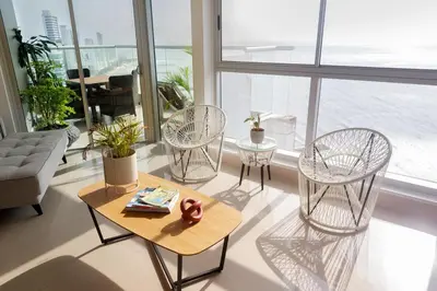 a living room with chairs and a table in front of a window at Murano Elite by MOME in Cartagena de Indias