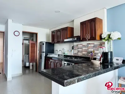 a kitchen with wooden cabinets and a black counter top at Apartamentos Torres Del Lago Por Parceros Group in Cartagena de Indias