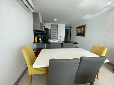 a kitchen and dining room with a white table and chairs at Apartamentos Palmetto Sunset por Parceros Group in Cartagena de Indias