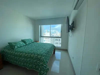 a bedroom with a bed and a large window at Apartamentos Palmetto Sunset por Parceros Group in Cartagena de Indias