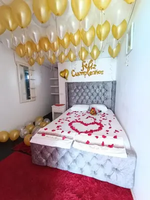 a bedroom with a bed with a bunch of gold balloons at Hotel Los Chamos Barú in Cartagena de Indias