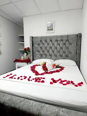 a bed with red roses on it with a white blanket at Hotel Los Chamos Barú in Cartagena de Indias