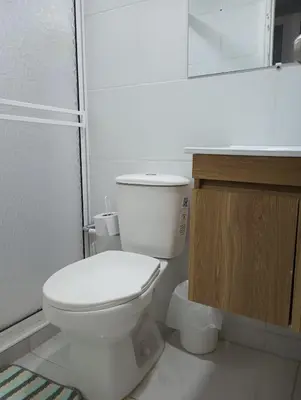 a white bathroom with a toilet and a sink at Balcon y Vista al Mar in Cartagena de Indias