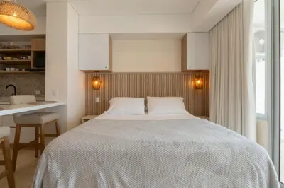 a bedroom with a large bed and a kitchen at Seaside Serenity and Style in Cartagena de Indias