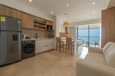 a kitchen and living room with a refrigerator and a table at Seaside Serenity and Style in Cartagena de Indias