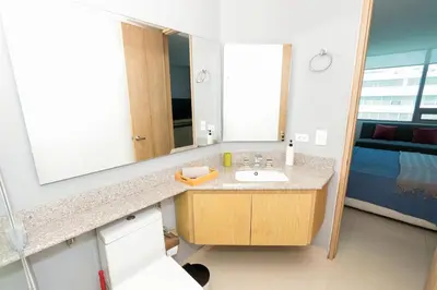 a bathroom with a sink and a large mirror at Bluegardens Apartment, Central with Beautiful View in Barranquilla