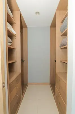 a walk in closet with wooden cabinets and a white floor at Bluegardens Apartment, Central with Beautiful View in Barranquilla