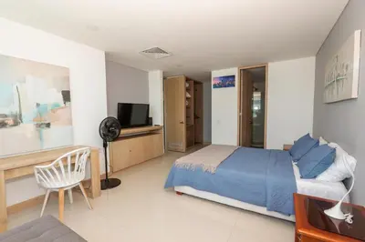 a bedroom with a bed and a tv and a chair at Bluegardens Apartment, Central with Beautiful View in Barranquilla