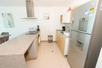 a kitchen with a white refrigerator and a counter at Bluegardens Apartment, Central with Beautiful View in Barranquilla