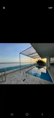 a picture of a swimming pool next to the ocean at El Laguito Apartamento in Cartagena de Indias