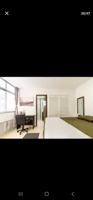 a bedroom with a bed and a desk and a chair at El Laguito Apartamento in Cartagena de Indias