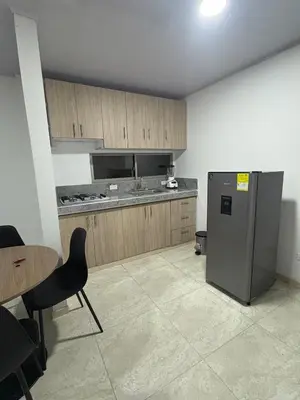 a kitchen with a stainless steel refrigerator and a table at Maru apartamentos in Cartagena de Indias