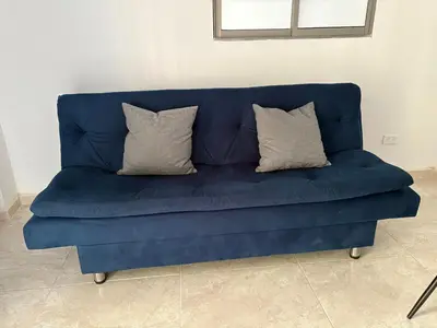 a blue couch with three pillows on it at Maru apartamentos in Cartagena de Indias