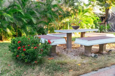 a picnic table and bench in a yard with flowers at Casa Niza - Colonial house in Cartagena de Indias