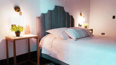a bedroom with a bed with a green headboard at Casa Niza - Colonial house in Cartagena de Indias
