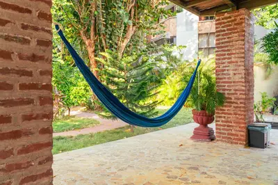 a blue hammock in a patio with a plant at Casa Niza - Colonial house in Cartagena de Indias