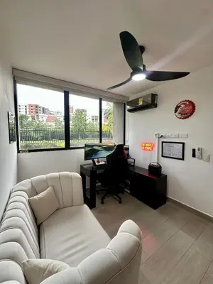 a living room with a couch and a ceiling fan at Luxury loft with home theater & pool, Buenavista top location in Barranquilla