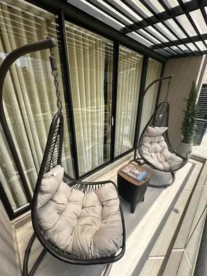 two swinging chairs on a porch with a table at Luxury loft with home theater & pool, Buenavista top location in Barranquilla