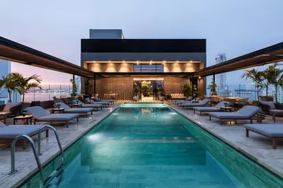 a swimming pool with lounge chairs and a building at OZ Hotel Collection in Cartagena de Indias